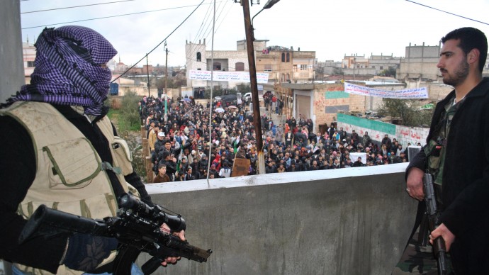 Syrian army defectors stand guard on a rooftop to secure an anti-Syrian regime protest in the Deir Baghlaba area in Homs province, central Syria, on Friday, Jan. 27, 2012. (AP Photo)