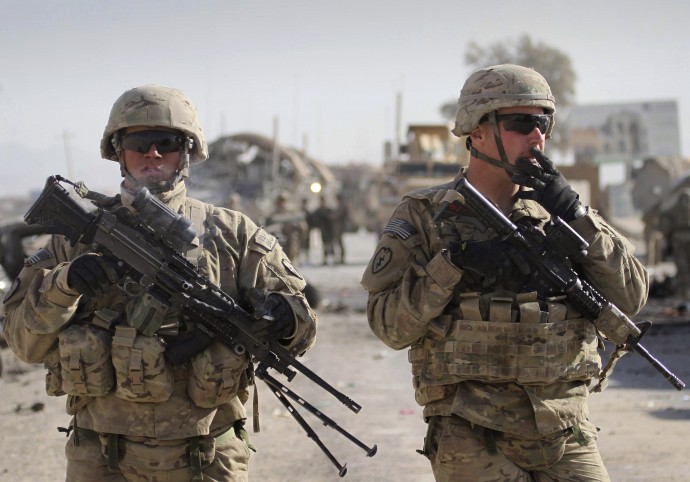 U.S. soldiers with the NATO led International Security Assistance Force (ISAF) stand guard at the scene of a suicide attack in Kandahar south of Kabul, Afghanistan, Thursday, Jan. 19, 2012. (AP Photo/Allauddin Khan)