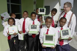 Children from Holmes Elementary School in the "5000 Role Models of Excellence" program show their nes XO laptops with Knight Foundation President Alberto Ibargüen.