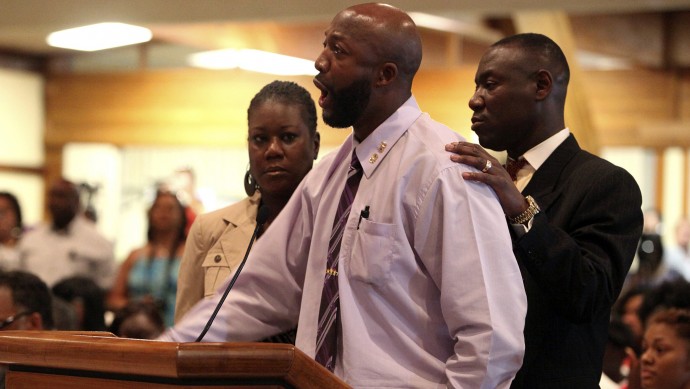 Tracy Martin, center, speaks at the Sanford City Commission meeting with Trayvon's mother, Sybrina Fulton, left, and the family lawyer, Benjamin Crump at the Sanford Civic Center in Sanford Fla., Monday, March 26, 2012. Matin's death has called many to question the legitimacy of the Stand your Ground legislation which is protecting Martin's killer from prosecution. (AP Photo/Julie Fletcher)