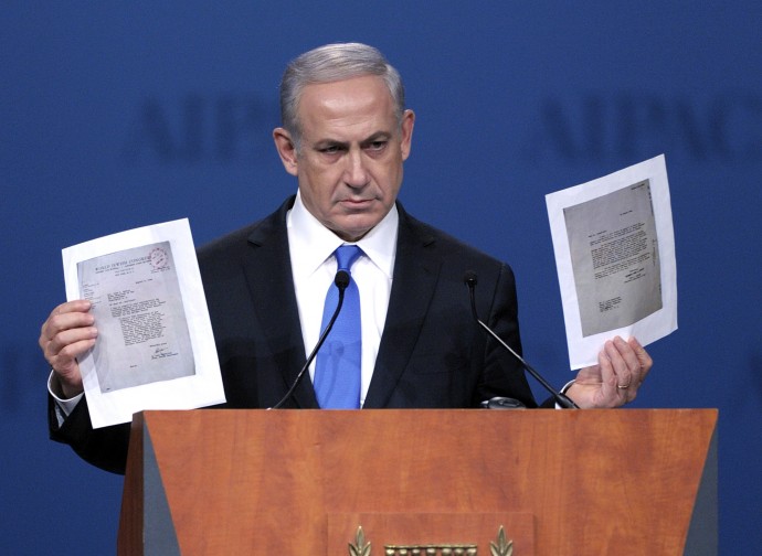 Israeli Prime Minister Benjamin Netanyahu holds two letters, one of which he read from, as he addresses the American Israel Public Affairs Committee (AIPAC) Policy Conference in Washington, Monday, March 5, 2012. (AP Photo/Cliff Owen)