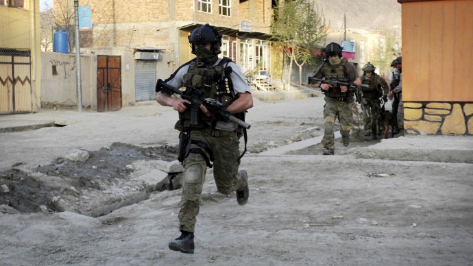 In an April 15, 2012 file photo NATO soldiers run during a gun battle in Kabul, Afghanistan. (AP Photo/Musadeq Sadeq/file)