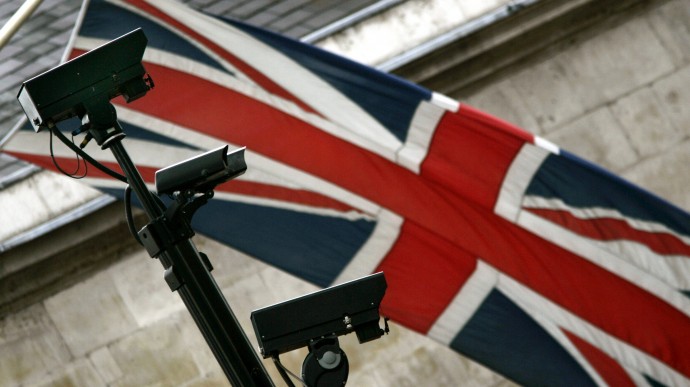 Backdropped by a British flag, closed-circuit surveillance cameras keep watch, in central London, Tuesday July 26, 2005. (AP Photo/Lefteris Pitarakis)