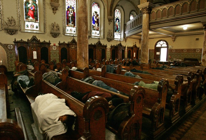 Homeless people sleep on pews at St. Boniface Church in San Francisco on Wednesday, Sept. 14, 2005. The church looks like an evacuation center, row after row of desperate people and their sparse belongings. This roomful of displaced people is neither an emergency shelter nor a temporary situation. It is the ongoing, daily, chronic disaster that is poverty in America.  (AP Photo/Ben Margot)