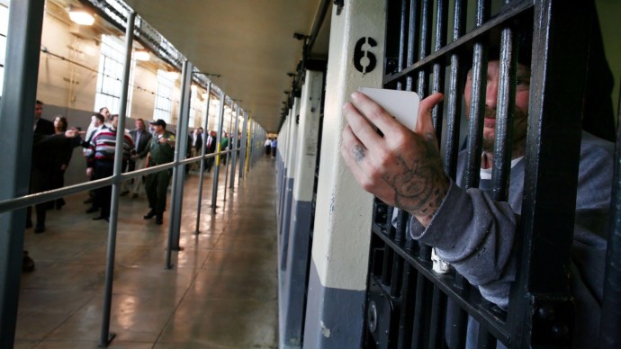 Folsom prison inmate Joseph Sweet uses his mirror to look at California Republican lawmakers visiting the inside of Folsom Prison, in Represa, Calif., Monday Feb. 5, 2007. (AP Photo/Brian Baer, Pool)