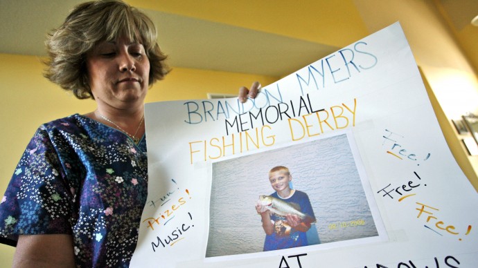Kim Myers holds a poster used to promote a memorial fishing derby in honor of her son, Brandon, who killed himself in February of  2007, in Lee's Summit, Mo. For Kim Myers, Brandon's death is the result of what she calls incessant bullying that his teachers and other administrators at Voy Spears Elementary School failed to stop. (AP Photo/Ed Zurga)