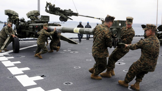 In this photo taken on Feb. 2, 2012 and released by U.S. Navy, U.S. Marines assigned to the 31st Marine Expeditionary Unit haul a 155 mm Howitzer onto the flight deck of the forward-deployed amphibious dock landing ship USS Germantown in Okinawa, Japan. The ship pulled into Okinawa to embark the Marines in preparation of exercise Cobra Gold 2012. (AP Photo/U.S. Navy, Mass Communication Specialist 1st Class Johnie Hickmon)