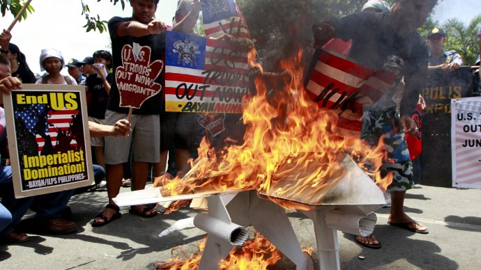 Protesters burn an effigy of a US military drone during a rally at the US Embassy in Manila, Philippines Friday April 13, 2012 to protest the annual joint-military exercise dubbed Balikatan 2012 (Shoulder-to-Shoulder) in the West Philippine Sea where the disputed Spratlys Group of islands is located. Thousands of US and Philippine troops are taking part in the annual military exercise which opens Monday. (AP Photo/Bullit Marquez)