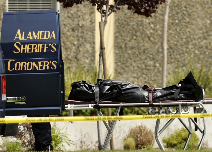 A body rests outside a coroner's van outside Oikos University in Oakland, Calif., Monday, April 2, 2012. A gunman opened fire at the university, killing at least five people, law enforcement sources close to the investigation said. Police say they have a suspect in custody. (AP Photo/Noah Berger)