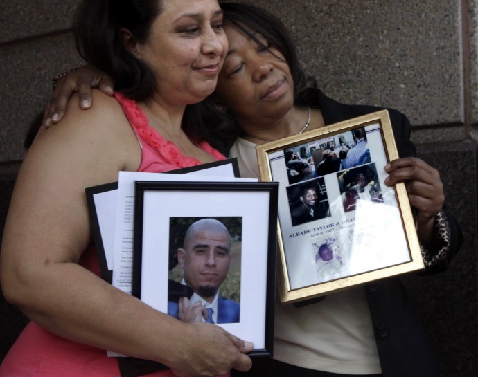 Ronnie Sandoval, left, Lorrain Taylor, comfort each other as they hold photos of their slain children, and a news conference where they joined others in supporting a Novemer 2012 ballot intiative to end the death penalty, held in Sacramento, Calif. Monday, Aug. 29, 2011. Sandoval's son, Arthur Carmona, was murdered in Santa Ana in 2008 and Taylor's twin sons with gunned down together in Oakland in 2000. Both mothers spoke against the death penalty and support the initiative that would replace capital punishment with life prison terms. (AP Photo/Rich Pedroncelli)
