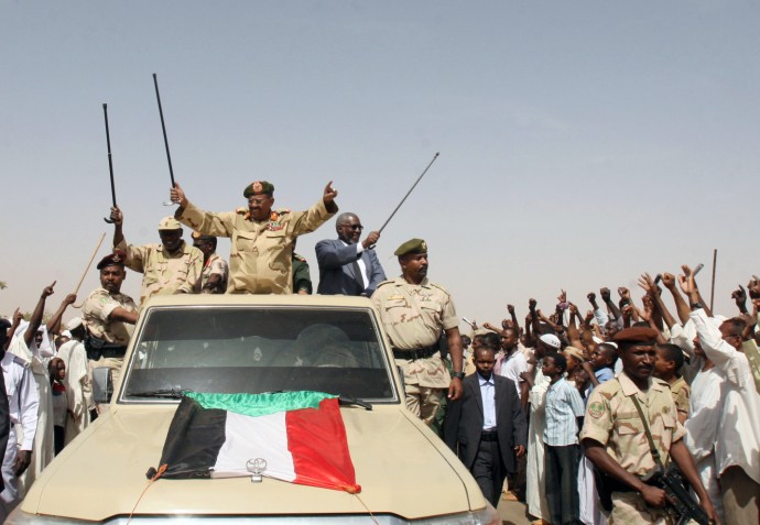Sudanese President Omar al-Bashir, center, waves from the back of a truck during a visit to North Kordofan, Sudan, Thursday, April 19, 2012. The Arab League said Thursday it would hold an emergency meeting over the increasing violence between Sudan and South Sudan. Sudan President Omar al-Bashir on Wednesday threatened to topple the South Sudan government after accusing the south of trying to take down his Khartoum-based government. Al-Bashir continued his hardline rhetoric on Thursday in an address to a "popular defense" brigade headed to the Heglig area. The ceremony was held in al-Obeid, in northern Kordofan. (AP Photo/Abd Raouf)
