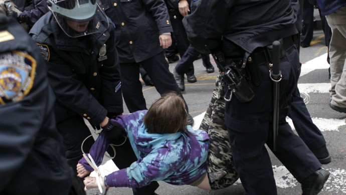 Police carry an Occupy Wall Street protester in handcuffs in New York, Thursday, Nov. 17, 2011.  Two days after the encampment that sparked the global Occupy protest movement was cleared by authorities, demonstrators marched through New York's financial district  and promised a national day of action with mass gatherings in other cities.  (AP Photo/Seth Wenig)