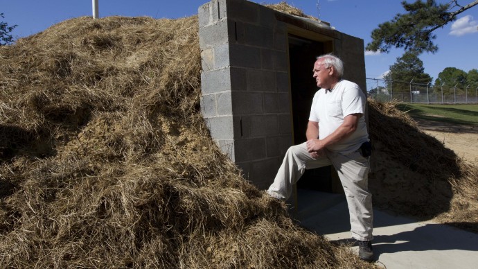 In this April 23, 2012, photo Freddie Wooten stands in front of the storm shelter he built at his own expense in Henager, Ala., following the 2011 tornado. When deadly twisters chewed through the Midwest and South in 2011, thousands of people in the killers' paths had nowhere to hide. Now many of those families are taking an unusual extra step to be ready next time: adding tornado shelters to their homes. (AP Photo/Dave Martin)