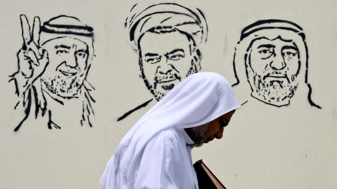 A Bahraini man passes images of jailed opposition leaders on a wall in Barbar, Bahrain, west of the capital of Manama, on Monday, April 30, 2012. Political leaders pictured from left are: Hassan Mushaima, Sheik Mohammed Habib Moqdad, and Abdulwahab Hussein. A defense lawyer says a Bahrain appeals court has ordered the reexamination of the case of the men's case as well as those of a prominent jailed hunger striker and several other jailed leaders. (AP Photo/Hasan Jamali)