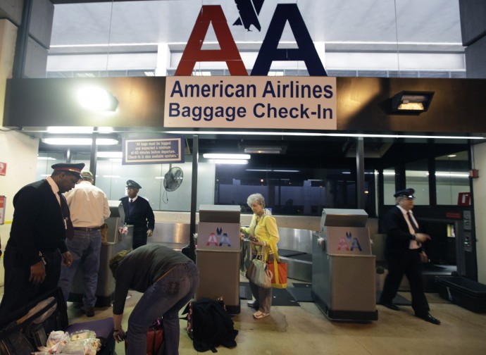 American Airlines baggage handlers help passengers check luggage at Dallas-Fort Worth International airport in Grapevine, Texas, Wednesday, Feb. 1, 2012. The Office of Special Counsel is criticizing airline safety tactics, saying regulators lag in response time to an emergency. (AP Photo/LM  Otero) 