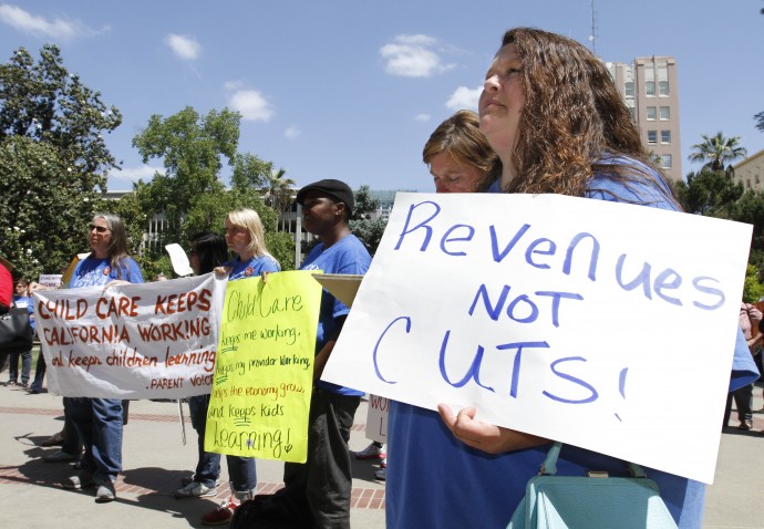 Jennifer Greppi, right, , joined others in a demonstration against further state budget cuts to social services at the Capitol in Sacramento, Calif., Monday,  May 14, 2012.  Gov. Jerry Brown  unveiled his revised state budget plan, Monday,  that includes an additional $8 billion in cuts to cover a $15.7 billion budget shortfall for the fiscal year that starts July 1.(AP Photo/Rich Pedroncelli)