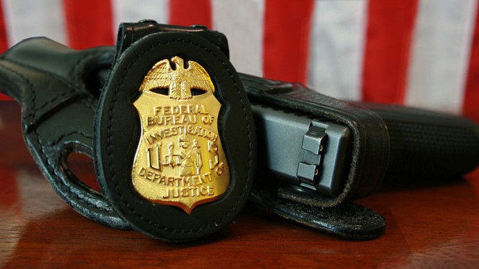 An FBI badge and service pistol. (Photo by the Federal Bureau of Investigation)