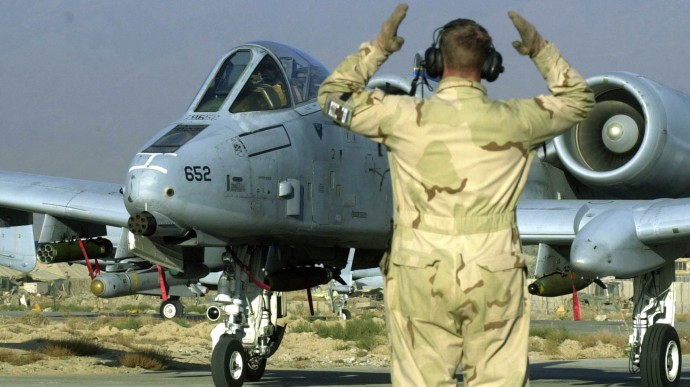 A ground crewman instructs movement to a U.S. Air Force pilot in an A-10 Thunderbolt attack jet prior to takeoff for a combat mission, in Bagram air base, northeast of Kabul, Afghanistan, Monday, Oct. 7, 2002. The first anniversary of the war in Afghanistan passed without fanfare as troops settle in for a long, low intensity mission. (AP Photo/Darko Bandic)