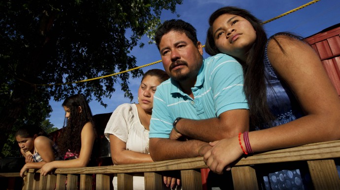 In this Thursday, April 13, 2012 photo, Diane Martell, 17, right, leans on her parents Maurcio and Guadalupe on the porch of their home in Bessemer, Ala. The Martells are illegal immigrants, as are most of the residents of this trailer park, and they live in fear of Alabama's harsh immigration laws. (AP Photo/Dave Martin)