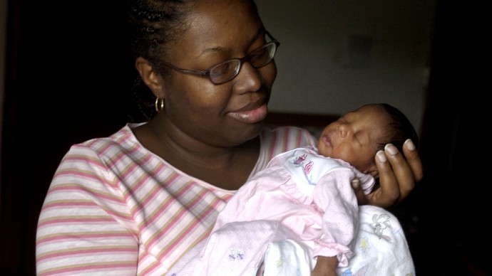 ** ADVANCE FOR SUNDAY, MAY 16 ** Nakida Maxson, whose friends joked that birthing classes and taking prenatal pills were things only white people did, holds her 15-day-old daughter, Dariya Jordan Smith, at home Friday, April 30, 2004, in Chicago.  With the black infant mortality rate more than twice as high as whites, Maxson was determined to not become part of that troubling statistical trend and ignored her friends saying "It's not a white people thing, it's a child thing."  (AP Photo/M. Spencer Green)