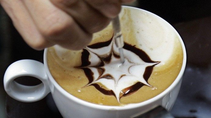 A Trung Nguyen Coffee staff member demonstrates how to create art work on a cup of coffee using milk and chocolate at their booth at the Coffee Culture Week expo in Hanoi,Vietnam, Friday, Nov. 30, 2007.  The expo is aimed at honoring Vietnamese coffee and promoting coffee sales inside the country.  The event will be held until Dec. 2 in Hanoi and then will moved to Ho Chi Minh City Dec. 13-16.  (AP Photo/Chitose Suzuki)