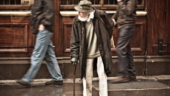An elderly man with a cane waits for a break in the traffic. A recent report states that retired couples may need $240,000 to pay for health care. (Photo by Garry Knight)