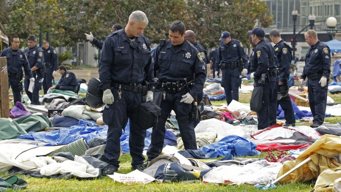 Oakland police officers sift through possessions left behind by Occupy Oakland protestors Tuesday, Oct. 25, 2011, in Oakland, Calif.. (AP Photo/Ben Margot)