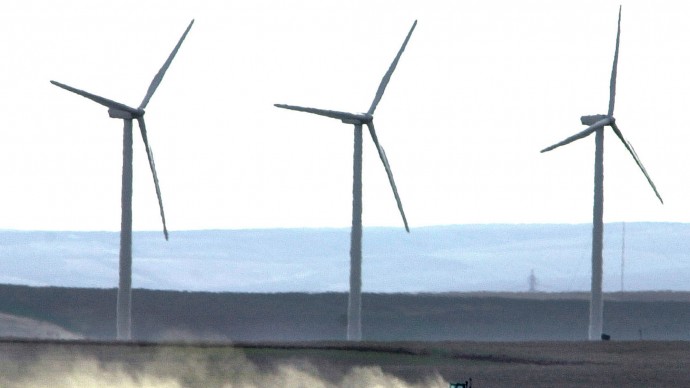 Wind turbines tower over farmland near Wasco, Ore., March 4, 2002. (AP Photo/Don Ryan, File)