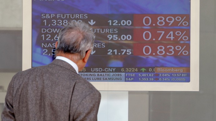 A man checks a stock exchange monitor in Milan, Italy, Monday, May 14, 2012.  (AP Photo/Antonio Calanni)