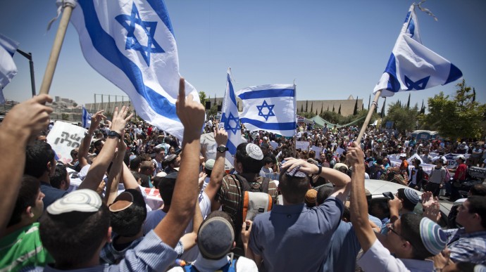 Jewish settlers wave Israeli flags during a protest against the proposed decision to evacuate a West Bank outpost in the Ulpana neighborhood, in the West Bank settlement of Beit El near the Palestinians city of Ramallah, outside the Supreme Court, in Jerusalem, Wednesday, June 6, 2012. (AP Photo/Oded Balilty)