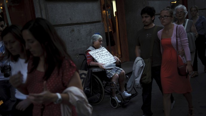 A woman begs in the street in Sol square in Madrid Sunday June 10, 2012. (AP Photo/Daniel Ochoa de Olza)