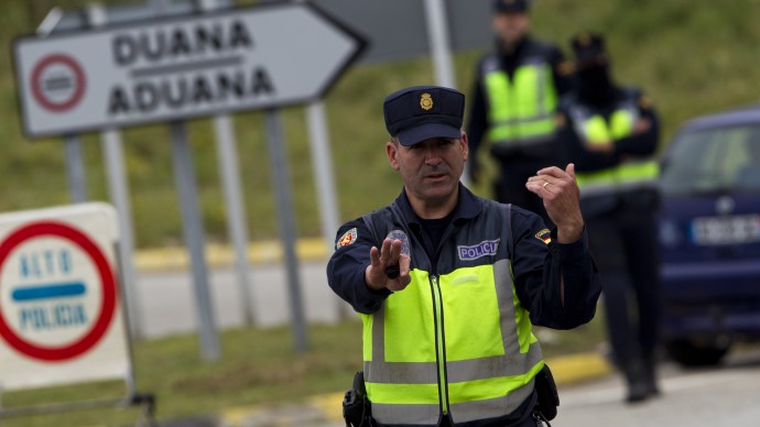 A police officer stops a vehicle in a checkpoint near to the border of Spain and France in La Jonquera, Girona, Spain, Saturday, April 28, 2012. (AP Photo/Emilio Morenatti)
