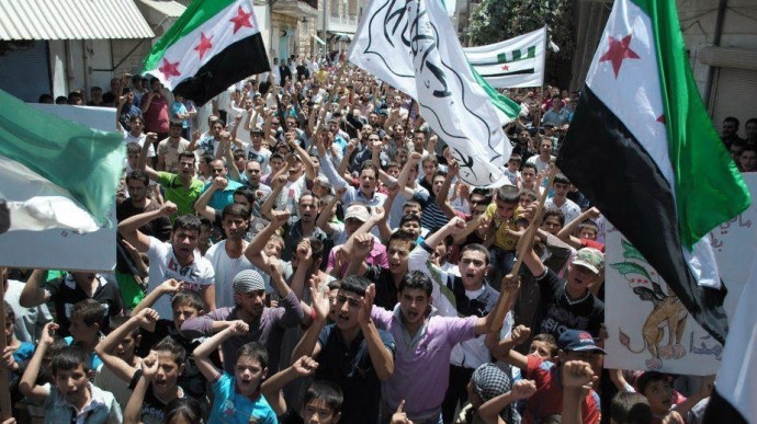 This citizen journalism image provided by Shaam News Network SNN, taken on Friday, July 6, 2012, purports to show protesters waving Syrian revolutionary flags and chanting slogans during a demonstration in Idlib, north Syria. (AP Photo/Shaam News Network, SNN)