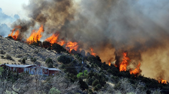 A wall of fire goes down a ridge close to Bannock Highway that has destroyed approximately 66 homes in the Mink Creek-Gibson Jack area just south of Pocatello. (AP photo, Doug Lindley/Idaho State Journal)