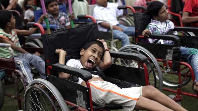 Indian children suffering with birth defects wait to compete in a wheel chair race during a "Special Olympics" held by the survivors of the deadly 1984 Bhopal gas leak in an effort to shame Olympic sponsor Dow Chemical Co. on the eve of the London Games in Bhopal, India, Thursday, July 26, 2012. (AP Photo/Altaf Qadri)