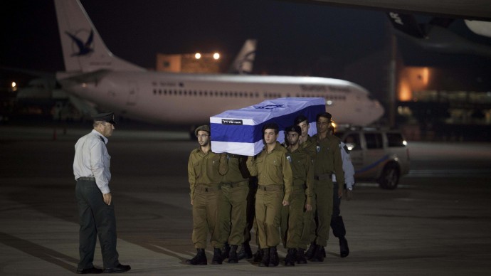 Israeli soldiers carry  the coffins of people killed in bombing in Bulgaria as the remains arrived to airport in  Tel Aviv, Israel, Friday, July, 20, 2012. The attack that left five Israelis dead occurred shortly after the Israelis boarded a bus outside the airport in the Black Sea resort town of Burgas, a popular destination for Israeli tourist. (AP Photo/Dan Balilty)