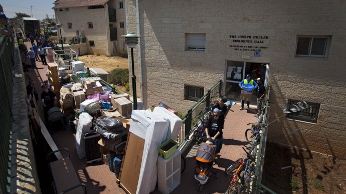 Jewish settlers and movers employed by the Israeli Defense Ministry carry out belongings from settler's apartment in the Ulpana neighborhood in the West bank Jewish settlement of Beit El, near Ramallah, Tuesday, June. 26, 2012. (AP Photo/Oded Balilty)