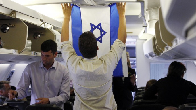 Aide Charlie Pearce examines an Israeli flag on the charter plane of Republican presidential candidate and former Massachusetts Gov. Mitt Romney before he boards at London Stansted Airport, Saturday, July 28, 2012, as he travels to Israel. (AP Photo/Charles Dharapak)