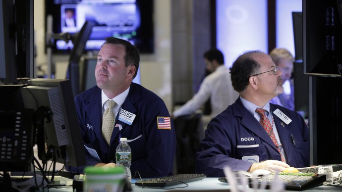 In this Tuesday, July 17, 2012, file photo, specialists Charles Boeddinghaus, left, and Douglas Johnson, work at their posts on the floor of the New York Stock Exchange. (AP Photo/Richard Drew, File)