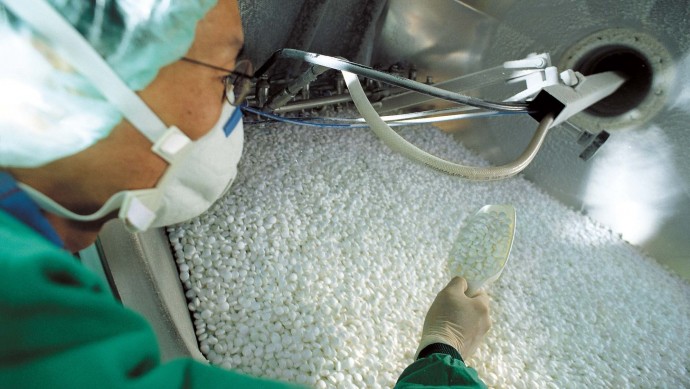An undated picture released by Merck KGaA shows an employee of pharmaceutical company Merck KGaA at a production line. (AP Photo/Merck, HO)