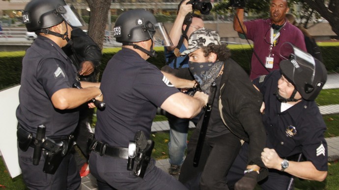 Los Angeles police officers struggle to arrest an unidentified protester in Los Angeles, Thursday, Nov. 17, 2011. (AP Photo/Damian Dovarganes)