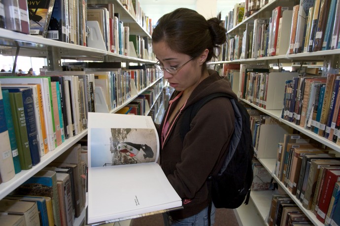 Wendy Barranco, a college student and Iraq war veteran looks at a photographic book on Iraq in Pasadena, Calif. Tuesday, March 18, 2008. (AP Photo/Damian Dovarganes)