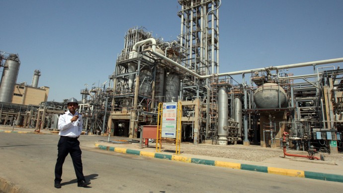 In this Wednesday, Sept. 28, 2011 file photo, an Iranian security guard stands at the Maroun Petrochemical plant at the Imam Khomeini port, southwestern Iran. (AP Photo/Vahid Salemi, File)