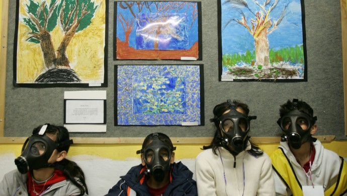 In this March 15, 2007 file photo Israeli school children wear gas masks during a drill organized by the Israeli Home Front Command simulating a chemical missile attack in a shelter at a school in the central Israeli city of Lod. (AP Photo/Oded Balilty, File)