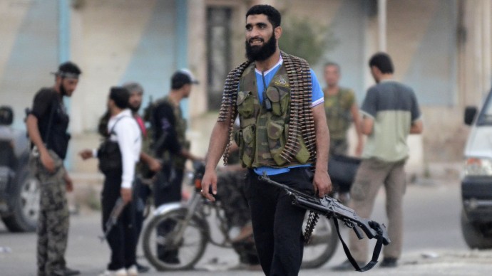 A Free Syrian Army soldier carries his weapon at the northern town of Sarmada, in Idlib province, Syria, Wednesday, Aug. 1, 2012. (AP Photo)