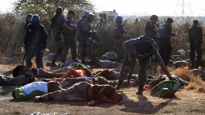 Police surround the bodies of striking miners after opening fire on a crowd  at the Lonmin Platinum Mine near Rustenburg, South Africa, Thursday, Aug. 16, 2012. (AP Photo)