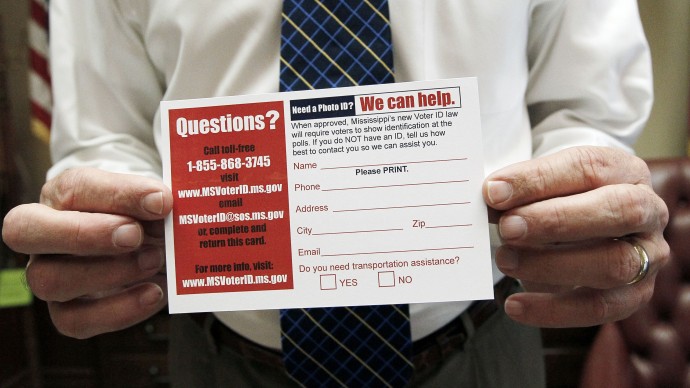 In this June 19, 2012 file photo, Mississippi Secretary of State Delbert Hosemann holds a postcard to help identify voters in need of a free state government issued card that will be issued through his office at no charge, in Jackson, Miss. More than two dozen states have some form of ID requirement, and 11 of those passed new rules over the past two years largely at the urging of Republicans who say they want to prevent fraud. (AP Photo/Rogelio V. Solis, File)