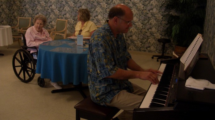 A man plays the piano at a nursing home in 2008 as residents listen. (Photo by robinsan via Flikr)