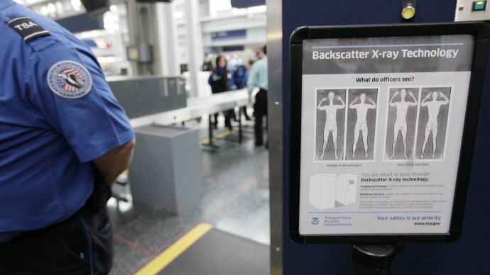 A sign next to a body scanner describes what TSA officers see on their computer screens, asvolunteers go through the first full body scanner installed at O'Hare International Airport , Monday, March 15, 2010, in Chicago. (AP Photo/M. Spencer Green)