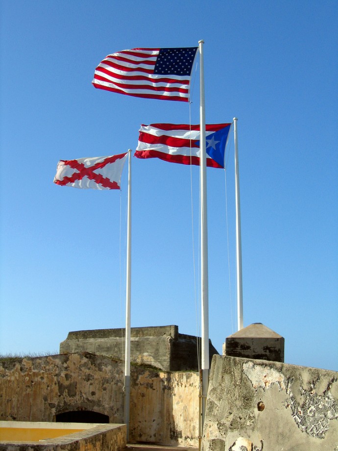 The U.S. and Puerto Rico flags fly near each other at Fort San Felipe del Morro in San Juan. (Photo by Tomas Fano via Flikr)